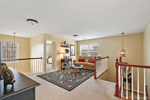 carpeted living room with plenty of natural light and a chandelier