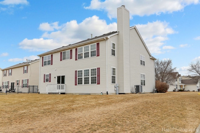 back of property featuring a lawn and central air condition unit