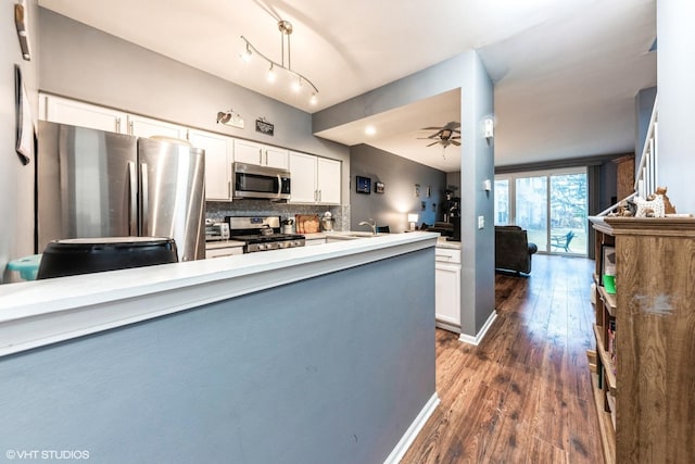 kitchen with stainless steel appliances, light countertops, dark wood-type flooring, and white cabinetry