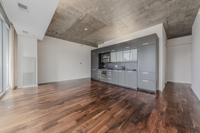 unfurnished living room featuring dark wood-type flooring and sink