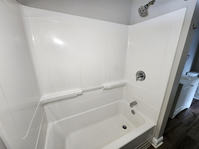 bathroom with hardwood / wood-style flooring and shower / bath combination