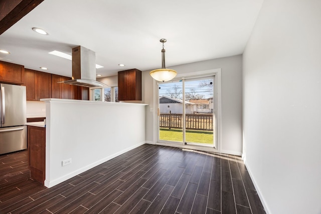 kitchen with island exhaust hood, pendant lighting, stainless steel fridge, and dark hardwood / wood-style flooring