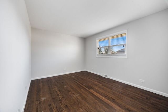 spare room with dark wood-type flooring