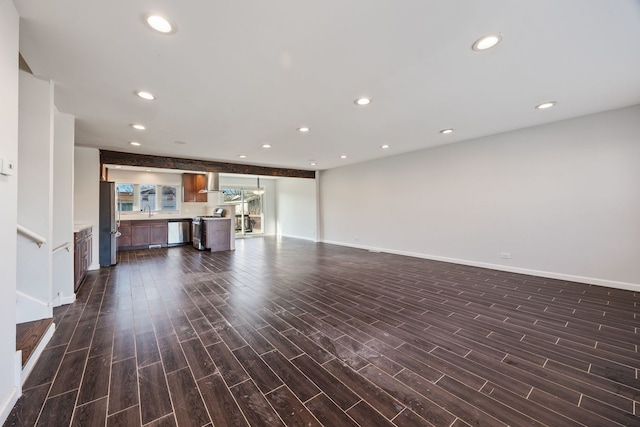 unfurnished living room featuring sink and dark wood-type flooring