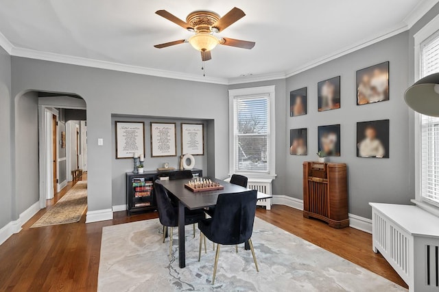 dining area with crown molding, wood-type flooring, and radiator