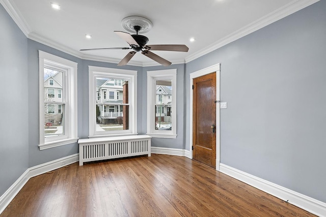 unfurnished room featuring crown molding, ceiling fan, radiator heating unit, and hardwood / wood-style floors