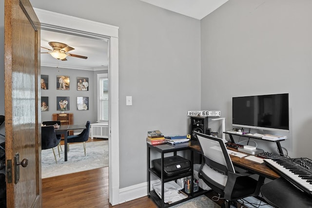 office space featuring crown molding, radiator, dark wood-type flooring, and ceiling fan