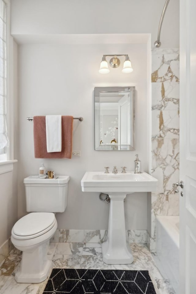 full bath with toilet, marble finish floor, and bathtub / shower combination