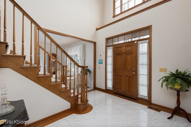 tiled entryway with a towering ceiling