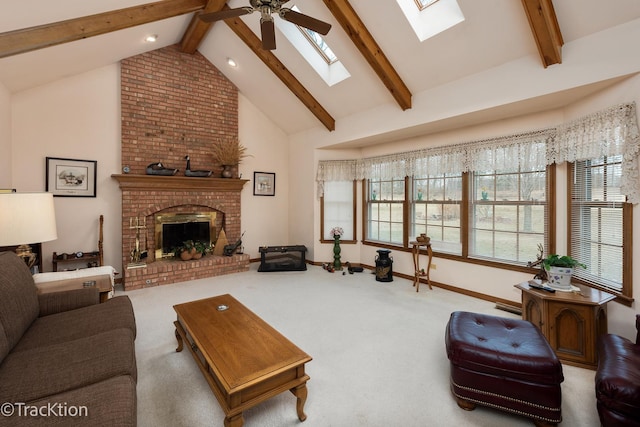 living room with high vaulted ceiling, a skylight, carpet floors, a brick fireplace, and beam ceiling