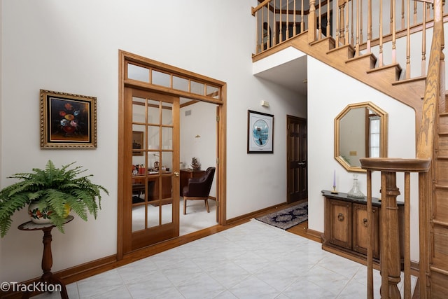 foyer entrance with french doors and a high ceiling