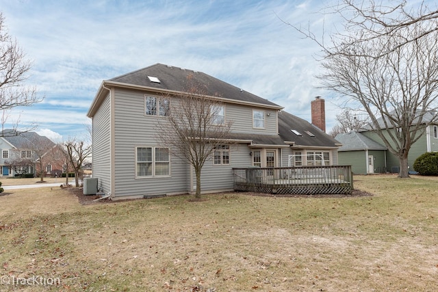 rear view of house with a wooden deck, a yard, and cooling unit