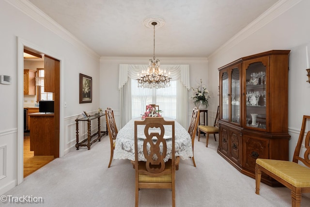 dining space featuring light carpet, a notable chandelier, and crown molding