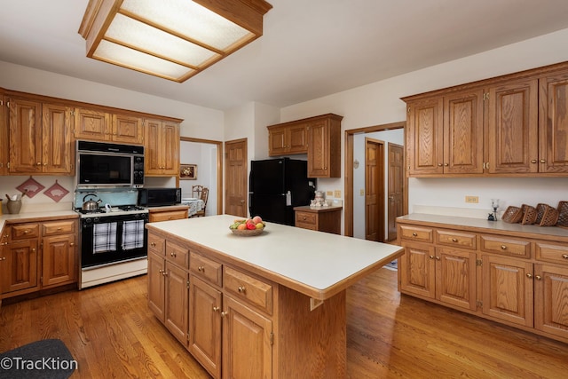 kitchen featuring light hardwood / wood-style flooring, black appliances, and a kitchen island