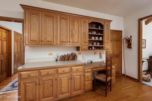 kitchen featuring built in desk and light hardwood / wood-style flooring