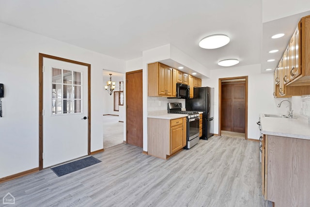 kitchen with sink, an inviting chandelier, light wood-type flooring, decorative backsplash, and black appliances