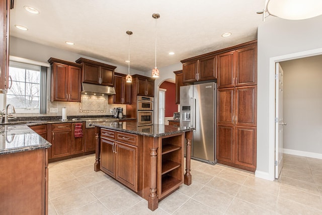 kitchen with decorative light fixtures, sink, backsplash, a center island, and stainless steel appliances