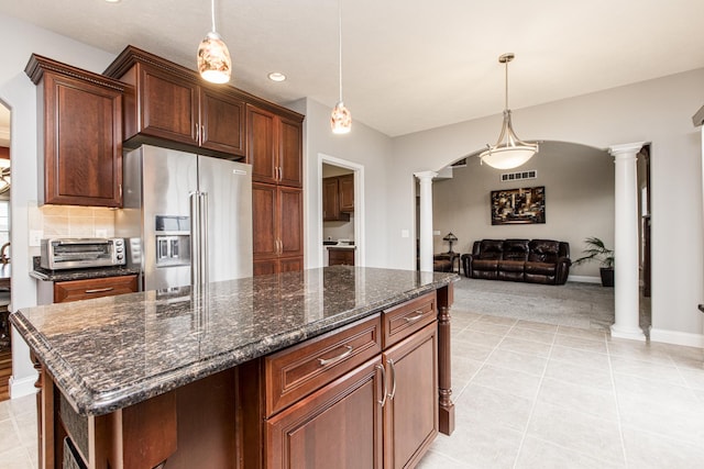 kitchen featuring pendant lighting, a kitchen island, high quality fridge, and ornate columns