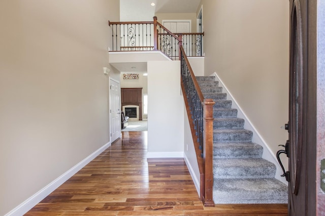 stairs with hardwood / wood-style flooring and a high ceiling