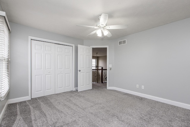 unfurnished bedroom featuring ceiling fan, a closet, and carpet