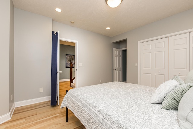 bedroom with hardwood / wood-style flooring, a closet, and a textured ceiling