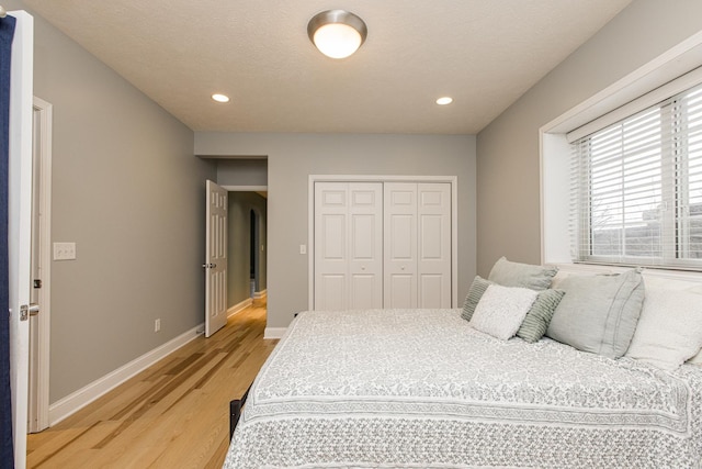 bedroom with hardwood / wood-style flooring, a closet, and a textured ceiling