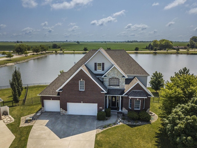 view of front of property with a water view, a garage, and a front lawn