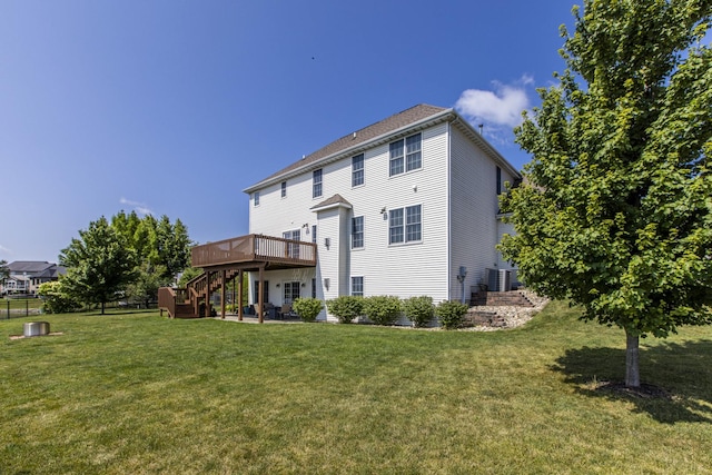 back of property with a wooden deck, a lawn, and central air condition unit