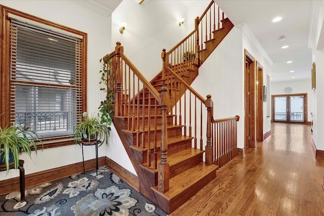 stairway featuring hardwood / wood-style flooring, ornamental molding, and french doors