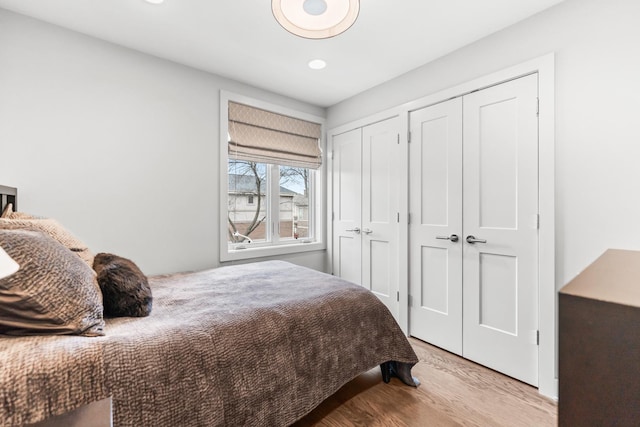 bedroom featuring wood finished floors and multiple closets