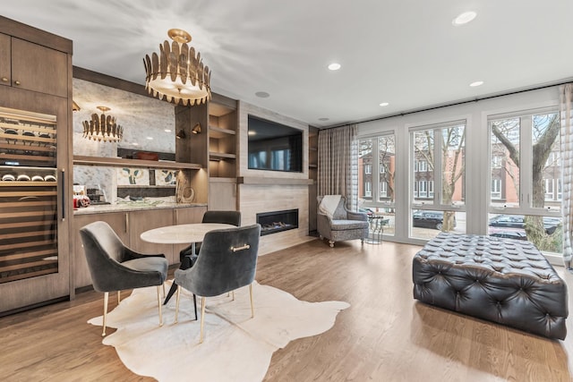 interior space featuring beverage cooler, wood finished floors, a high end fireplace, and recessed lighting