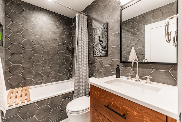 bathroom with tile walls, toilet, tiled shower / bath, vanity, and backsplash