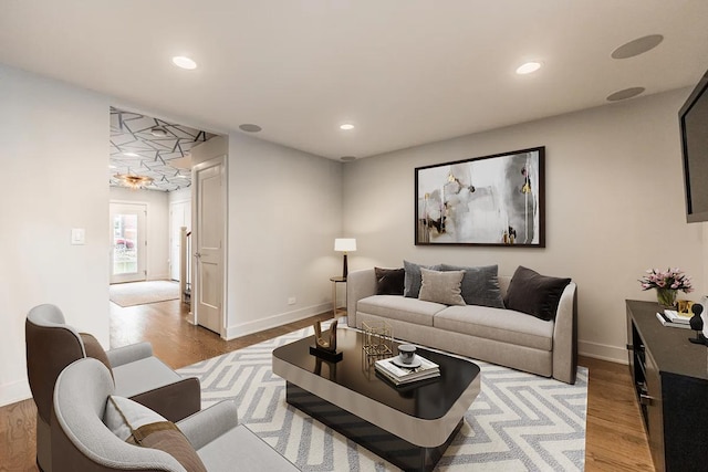 living room with recessed lighting, light wood-style flooring, and baseboards