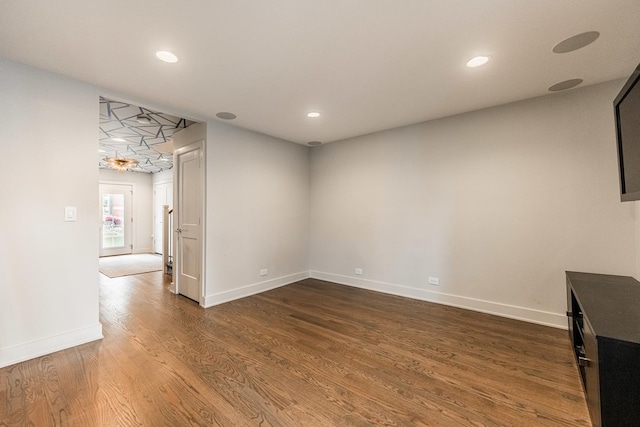 unfurnished living room featuring dark wood-type flooring, recessed lighting, and baseboards