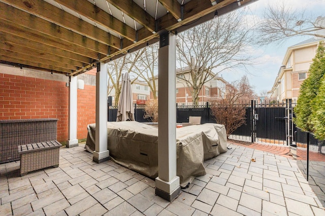 view of patio with a gate, fence, and a hot tub