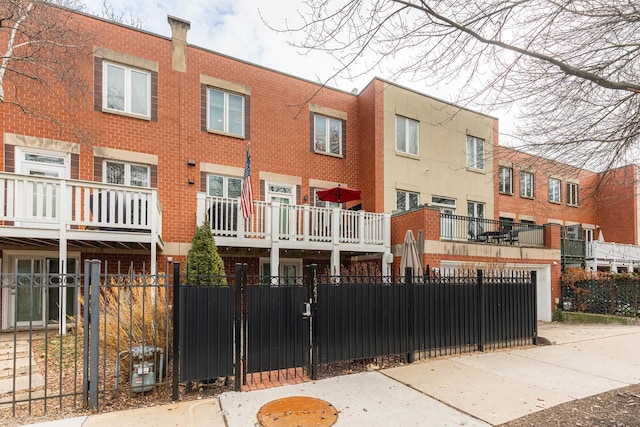 townhome / multi-family property featuring brick siding and fence