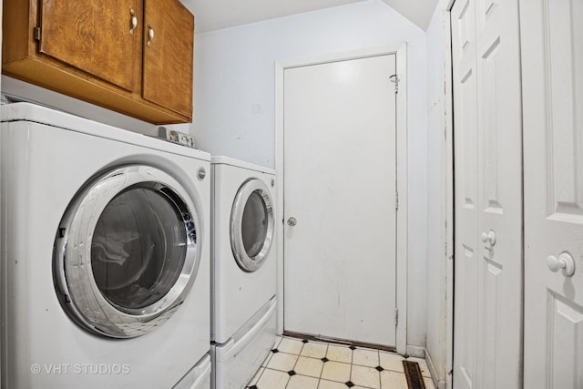 washroom featuring light floors, separate washer and dryer, and cabinet space