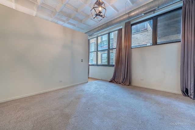 unfurnished room featuring coffered ceiling, plenty of natural light, beamed ceiling, and carpet flooring