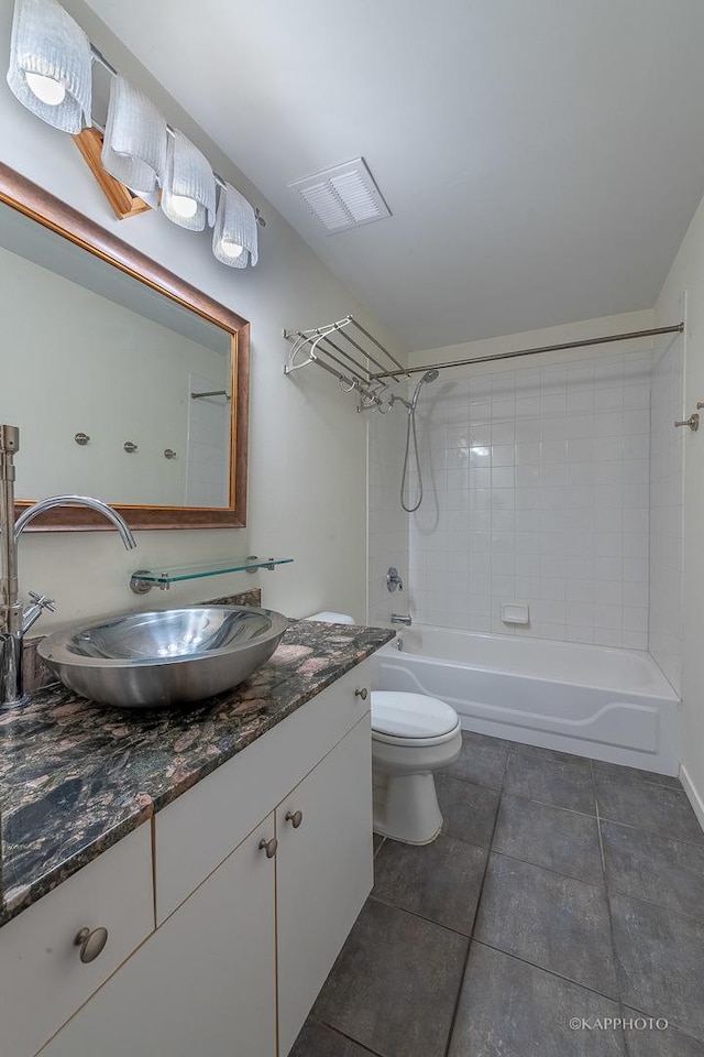 full bathroom featuring tiled shower / bath combo, vanity, tile patterned flooring, and toilet