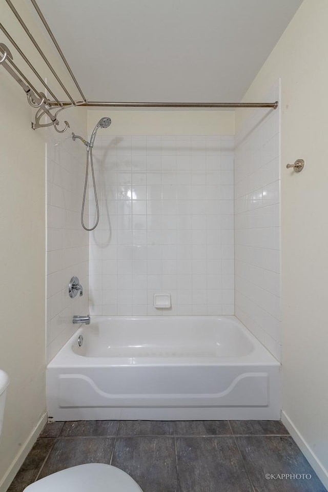 bathroom with toilet and tiled shower / bath combo