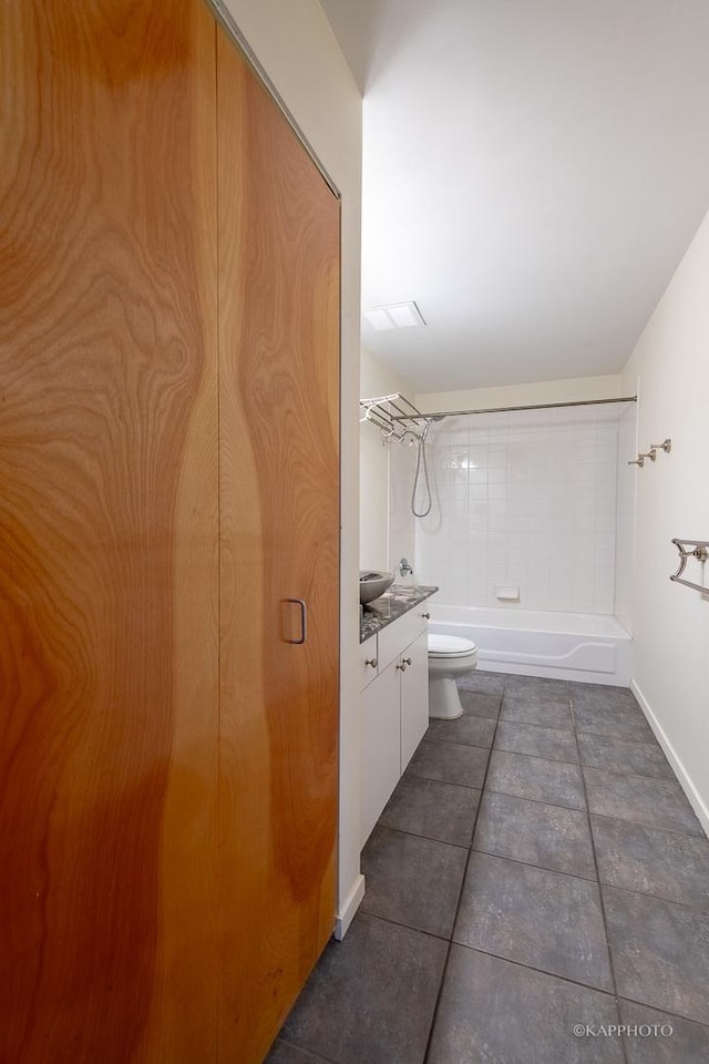 full bathroom featuring vanity, tiled shower / bath combo, tile patterned floors, and toilet