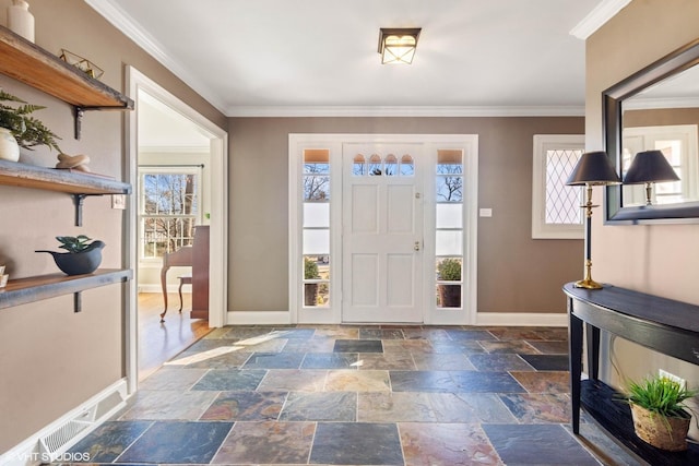 foyer with ornamental molding, stone tile flooring, and baseboards