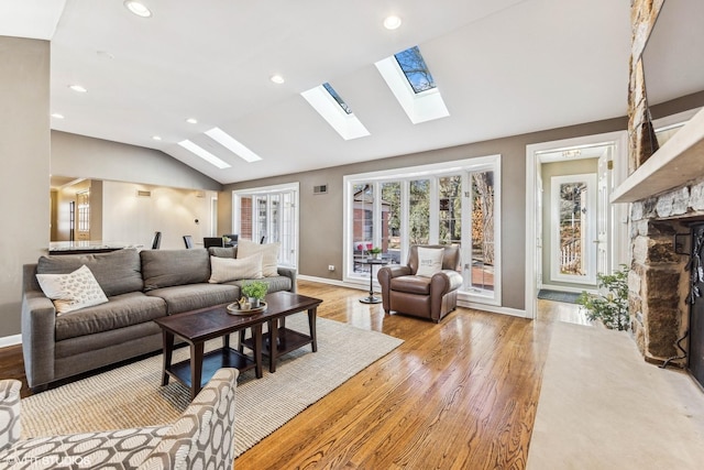 living area featuring light wood-style flooring, recessed lighting, visible vents, baseboards, and vaulted ceiling