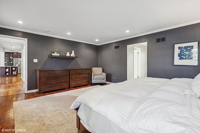 bedroom featuring baseboards, wood finished floors, visible vents, and recessed lighting