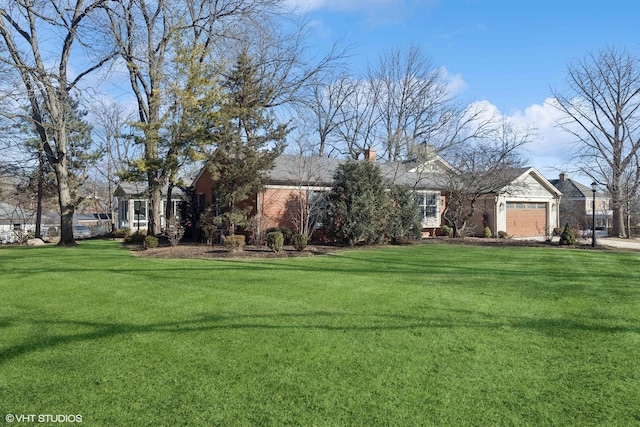 exterior space featuring an attached garage, brick siding, a chimney, and a front yard