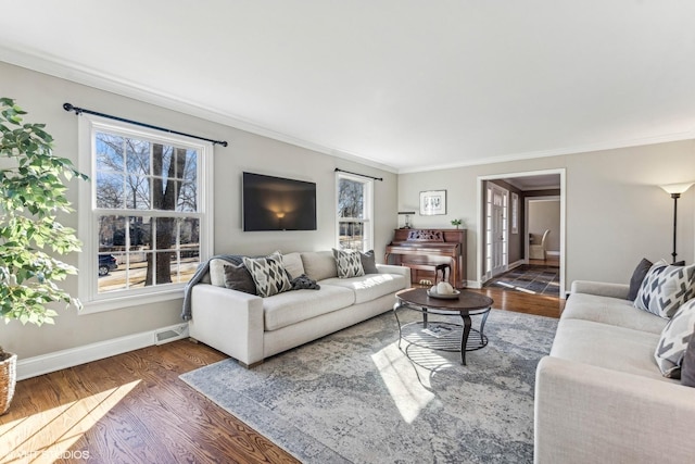 living area with dark wood-type flooring, visible vents, ornamental molding, and baseboards