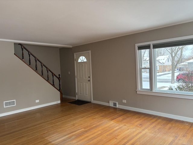 entrance foyer featuring ornamental molding and light hardwood / wood-style floors