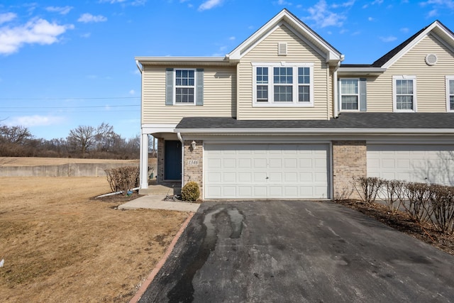 view of front of home with brick siding, driveway, and an attached garage