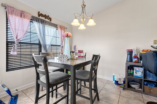 dining area featuring an inviting chandelier, tile patterned flooring, and baseboards