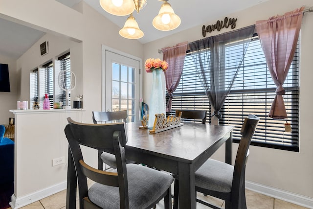 dining room with lofted ceiling, light tile patterned floors, and baseboards